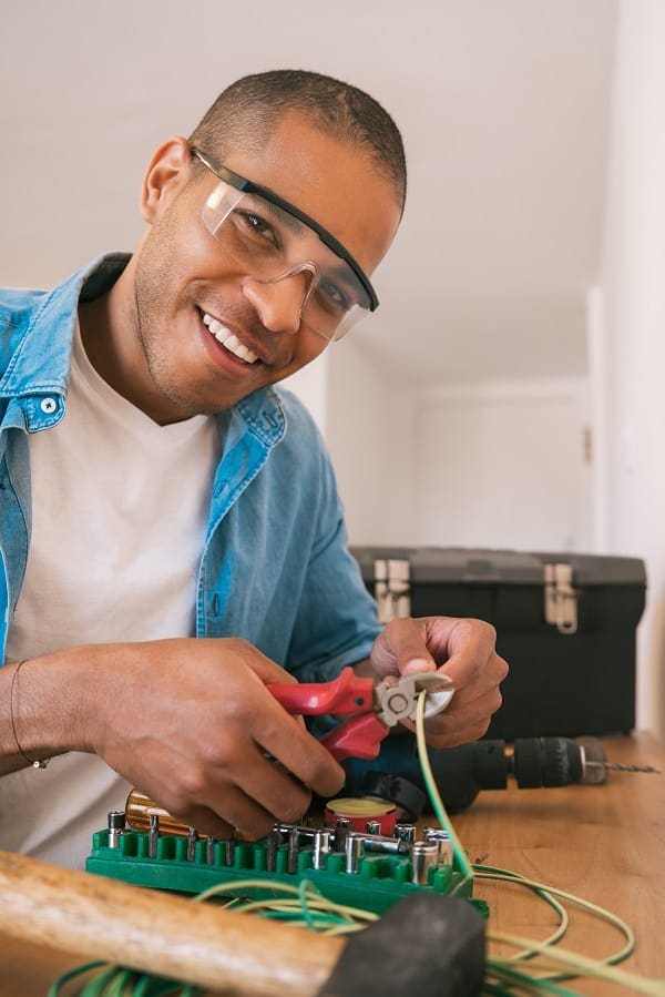 latin man fixing electricity problem at home XZCVNWA